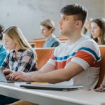 Handsome Caucasian Student Uses Laptop While Listening To A Lecture At The University Multi Ethnic Group Of Modern Bright Students Invested In Their Future