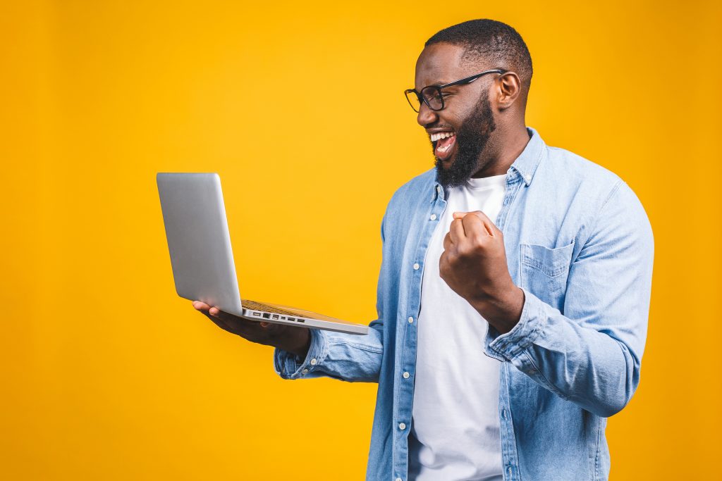 Excited Happy Afro American Man Looking At Laptop Computer Scree