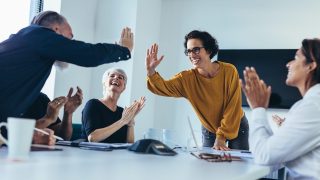 Business people giving each other high five and clapping. Business team celebrating success.