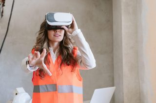 architect woman in construction site using virtual reality goggles working on VR blueprints