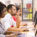 Multiracial Group Of Students Training In Computer Class